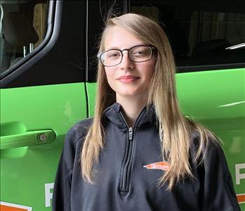 Female SERVPRO Technician in front of a SERVPRO vehicle