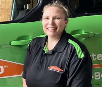 Female SERVPRO Technician in fromt of a SERVPRO vehicle